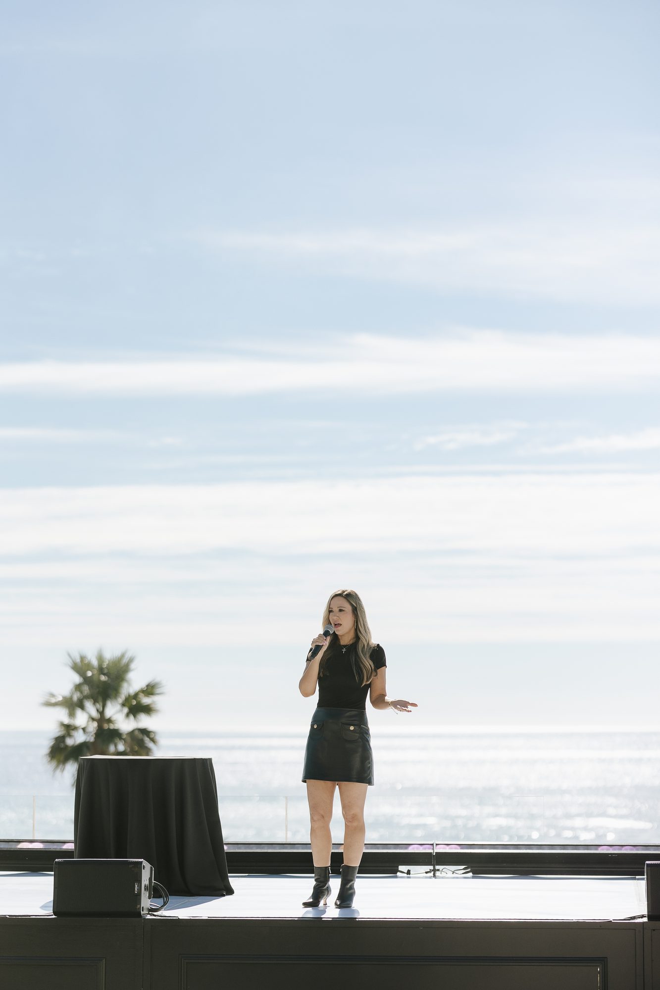 Anne Farrens speaking on stage in Malibu